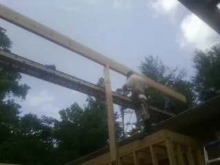 Carpenter setting a ridge beam over a new addition frame — Ice Dam Removal by Roofing Brothers in Chrisney