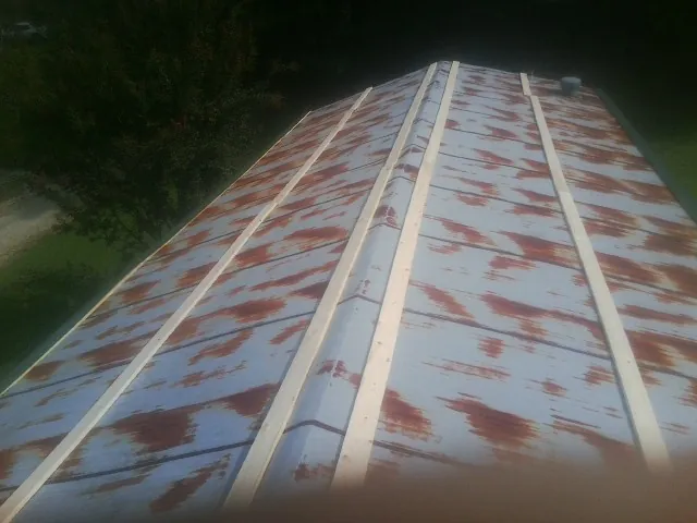 Rusted metal roof panels with new wood purlins before replacement — Storm Damage Roof Repair in Chrisney by Roofing Brothers