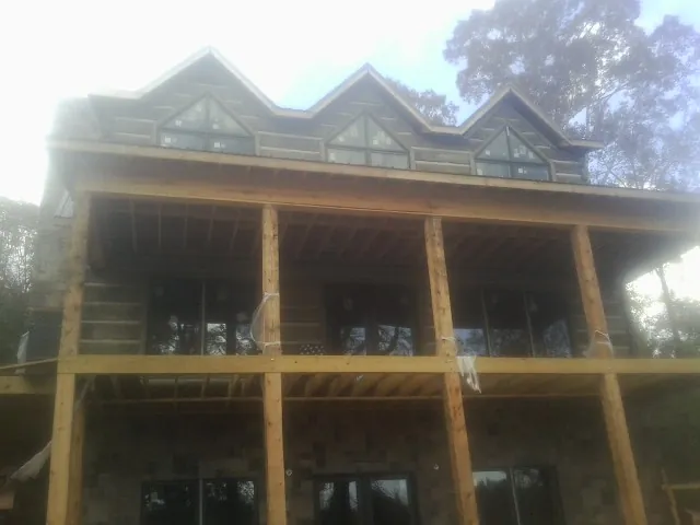 Dormers and porch framing on a large log home under construction — Roof Coating work by our crew in Chrisney